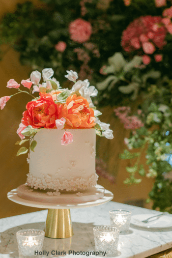 Single tier blush celebration cake with sugar flower decoration on top